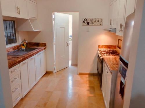 una cucina con armadietti bianchi e pavimenti in legno di Spacious 2-Bedroom Condo in Bellavista, Guayaquil a Guayaquil