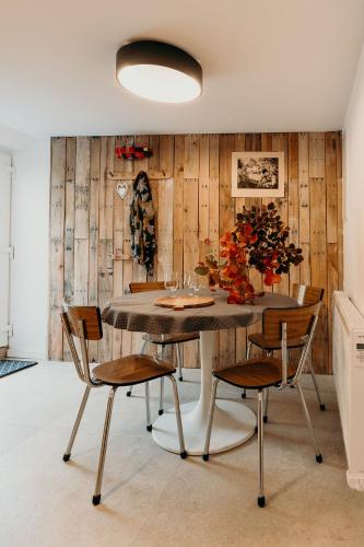 a dining room with a table and four chairs at Aux larges pierres in Anhée