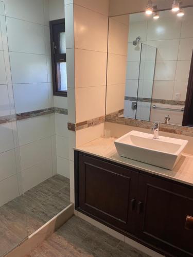 a bathroom with a sink and a shower with a mirror at Amplia, 4 dormitorios y piscina climatizada in Punta del Este