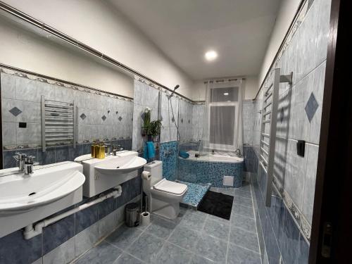 y baño con 2 lavabos, aseo y bañera. en Large 3 bedroom apartment with city skyline view, en Karlovy Vary