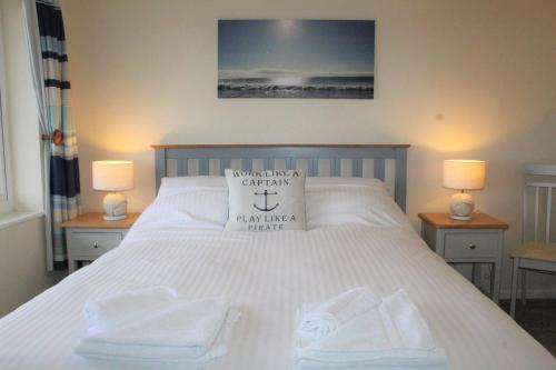a bedroom with a bed with white towels on it at Lobster Pot - Mount Brioni in Downderry