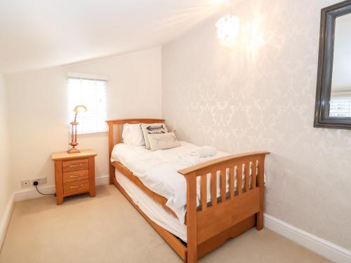 a bedroom with a bed and a wooden crib at 4 East Green, Southwold in Southwold