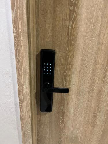 a black remote control on a wooden door at Espectacular apartamento en Condominio con BBQ in Ricaurte