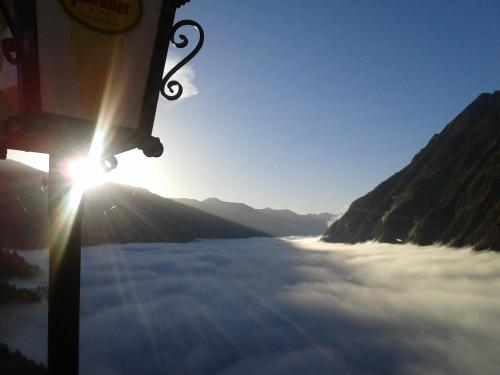 a view from the back of a bus with the sun above the clouds at Ferienwohnung Hohe Wand in Heiligenblut