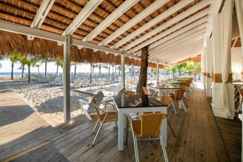 a dining room table with chairs and umbrellas at Viva Wyndham V Heavens, All Inclusive Resort in San Felipe de Puerto Plata