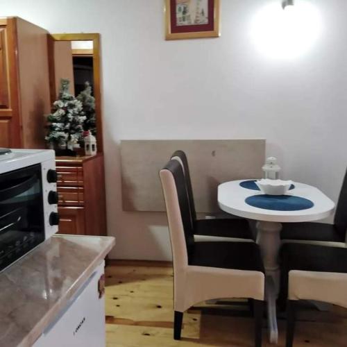 a kitchen with a table and chairs and a christmas tree at Simic Apartmani Tara in Kaludjerske Bare