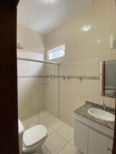 y baño con aseo, lavabo y ducha. en Aconchegante casa com piscina, en Florianópolis