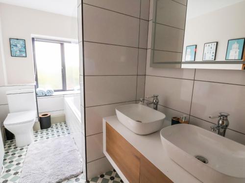 a white bathroom with a sink and a toilet at 3 Penllan Cottages in Holywell