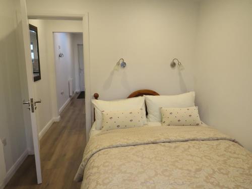 a bedroom with a large bed with two pillows at Lavender Mews in Tuam