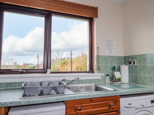 une cuisine avec un évier et une fenêtre dans l'établissement 25 Langlands Terrace, à Kyle of Lochalsh