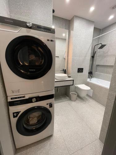 uma casa de banho com uma máquina de lavar e secar roupa. em Apartment Florence моря 600 метров em Aktau