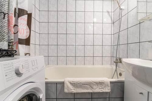 a bathroom with a tub and a sink and a washing machine at JAD - Family Studio - Soarelui 8 in Braşov