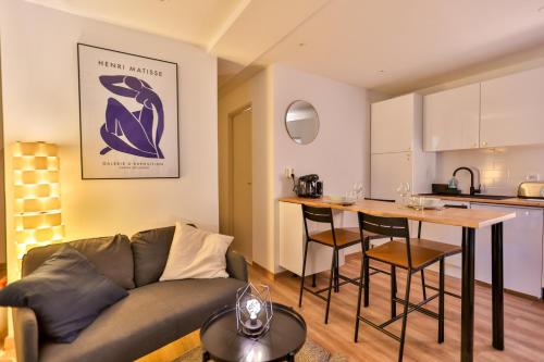 un salon avec un canapé et une table et une cuisine dans l'établissement L'iris #Netflix #Centre-ville, à Cognac