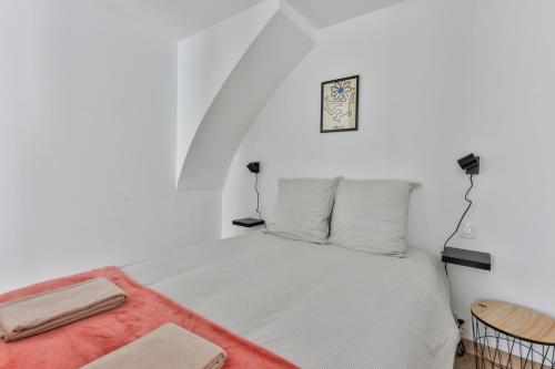 Un dormitorio blanco con una cama y una silla. en L'iris #Netflix #Centre-ville, en Cognac