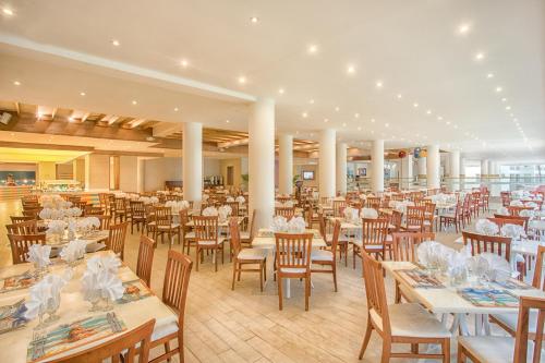 a dining room with tables and chairs and white tables and chairs at Viva Tangerine by Wyndham, A Trademark All Inclusive in Cabarete