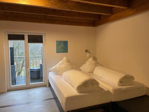 2 białe łóżka w pokoju z balkonem w obiekcie Gästehaus Sille in Morsbach - Holpe w mieście Morsbach