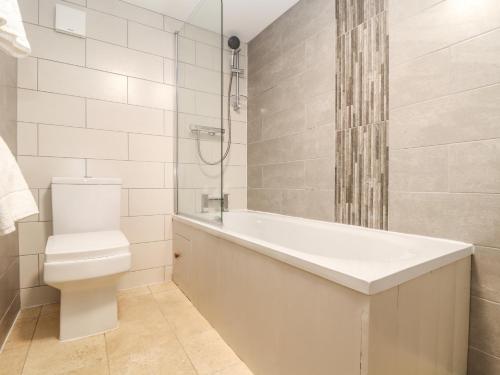 Un baño con bañera, inodoro y ducha. en Ty Bryn, en Marazion