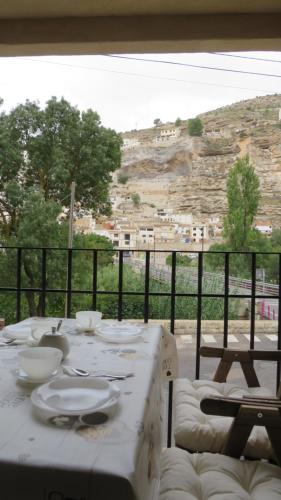 een witte tafel met borden en kommen op een balkon bij Casa Rural Pepe el Tranquilo in Alcalá del Júcar