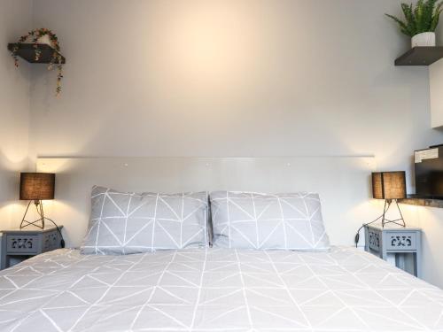 a bedroom with a white bed with two lamps at The Park Inn Piggery in Newton Abbot