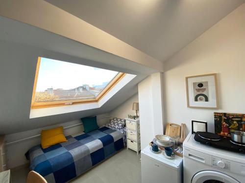 um pequeno quarto com uma cama e uma janela em LK17 - Loft in the Center em Sófia