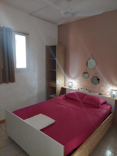 een slaapkamer met een groot bed met een rode deken bij Villa in Baie Mahault