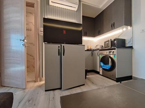 a kitchen with a refrigerator and a washing machine at privet (34)near downtown kh&sh in Ash Shumaysānī