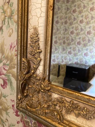 a mirror with a gold frame on a wall at The Elizabeth Inn and Restaurant in Bethel