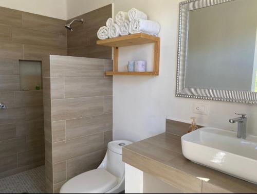 La salle de bains est pourvue de toilettes, d'un lavabo et d'un miroir. dans l'établissement Villa Paraíso, à La Ventana