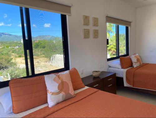 a bedroom with two beds and large windows at Villa Paraíso in La Ventana