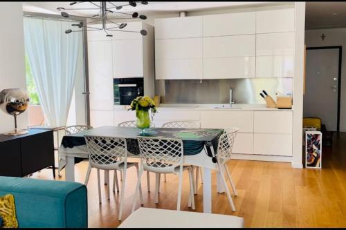 una cucina con tavolo e sedie e una cucina con armadietti bianchi di Casa Florenzia a Porto San Giorgio