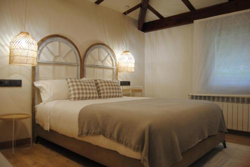 um quarto com uma cama grande e 2 candeeiros em Hotel a Ecogranxa em Pontevedra