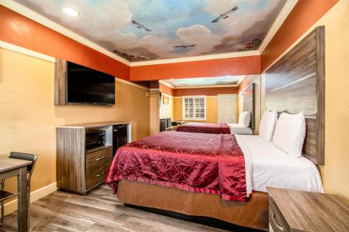 a hotel room with a bed and a tv at Geneva Motel in Inglewood