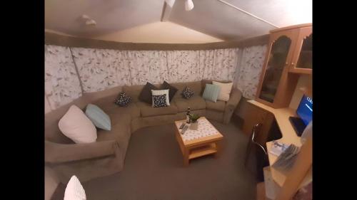 a living room with a couch and a table at Lovely 4 berth static caravan, Marine Holiday Park, Rhyl, Wales in Rhyl