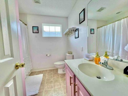 a white bathroom with a sink and a toilet at Lovely Home Near Myrtle Beach in Myrtle Beach