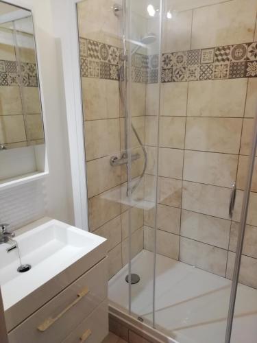 een badkamer met een douche en een wastafel bij Bel appartement avec jardin à 50m des plages du debarquement in Bernières-sur-Mer