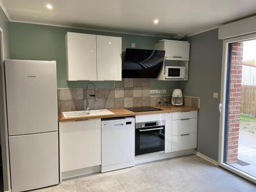 une cuisine avec des armoires blanches et un évier dans l'établissement Gîtes 6A et 6B, à Bailleul-Sir-Berthoult