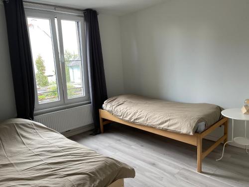 1 Schlafzimmer mit 2 Betten und einem Fenster in der Unterkunft House between Antwerp and Brussels in Rumst