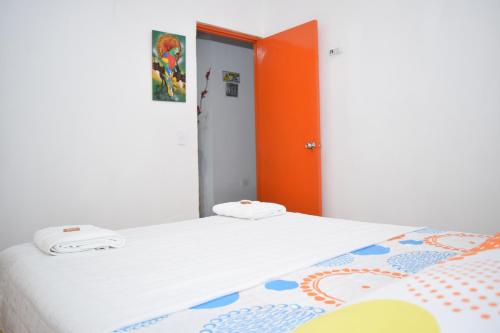 a bedroom with two beds and an orange door at HOSTAL LA MACARENA in El Zaino