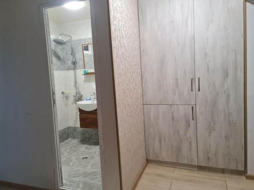 een badkamer met een douche en een glazen deur bij Saburtalo in Tbilisi City