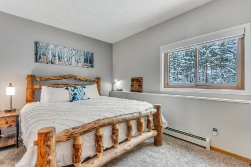 een slaapkamer met een houten bed en een raam bij Timber Ridge Retreat in Silverthorne