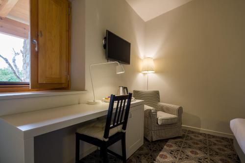 a room with a desk with a chair and a television at Masseria Agriturismo Torre Di Albidona in Trebisacce