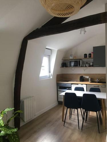 une cuisine avec une table et des chaises dans une pièce dans l'établissement Appartement en cœur de ville, à Angers