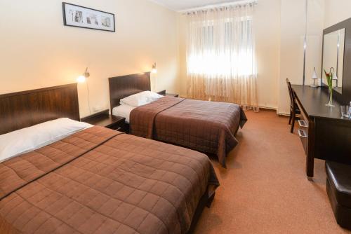 チェシンにあるHotel Liburniaのベッド2台とデスクが備わるホテルルームです。