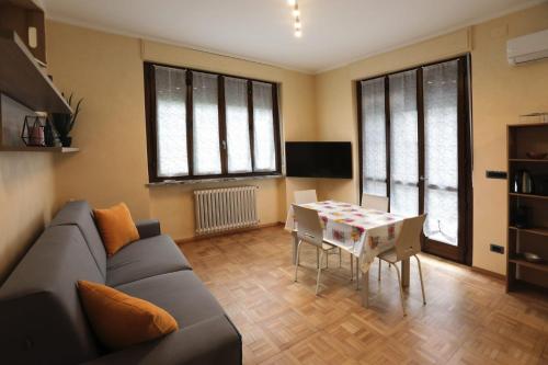 sala de estar con sofá y mesa en Langhe Apartament, en Monforte dʼAlba