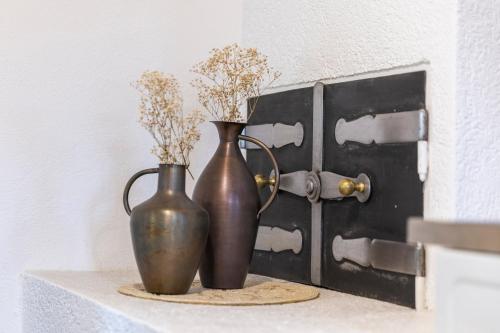 two vases sitting on a shelf next to a door at Das Ferienhaus mit Sauna! Neu renoviertes "Liebler Heimathaus" mit Sauna aus Zirben-Altholz, einer "Styrian Whisky Relaxing Lounge" sowie großer Panoramaterrasse! 