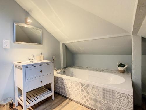 La salle de bains est pourvue d'une baignoire et d'un lavabo. dans l'établissement Aux Magnolias, Maison proche Colmar et Munster, à Zimmerbach