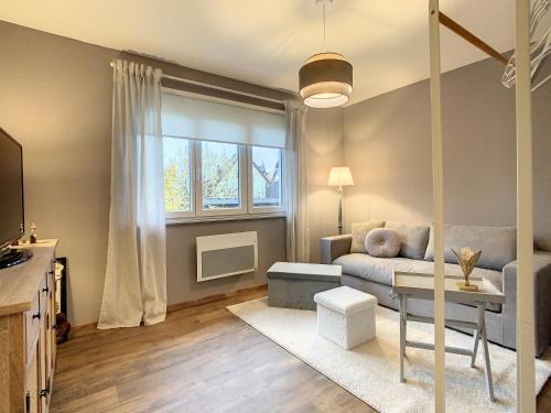 un salon avec un canapé et une table dans l'établissement Aux Magnolias, Maison proche Colmar et Munster, à Zimmerbach