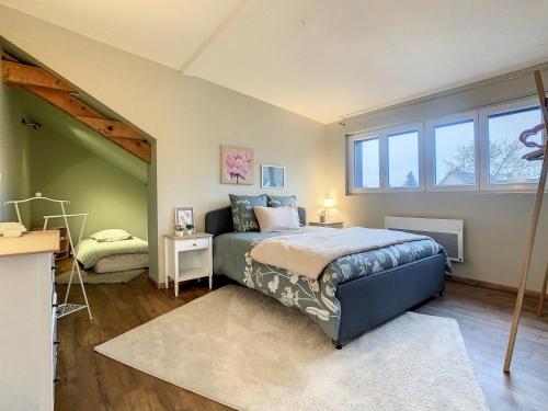 um quarto com uma cama e uma grande janela em Aux Magnolias, Maison proche Colmar et Munster em Zimmerbach