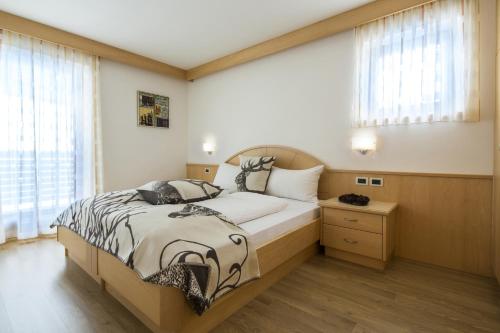 - une chambre avec un grand lit et une fenêtre dans l'établissement Ciasa Vilin, à Corvara in Badia