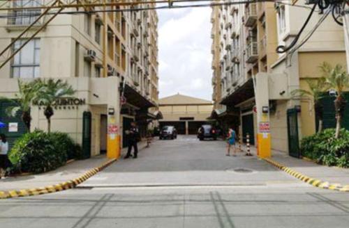 a street with buildings and people walking down the street at Marquinton Place City View in Manila